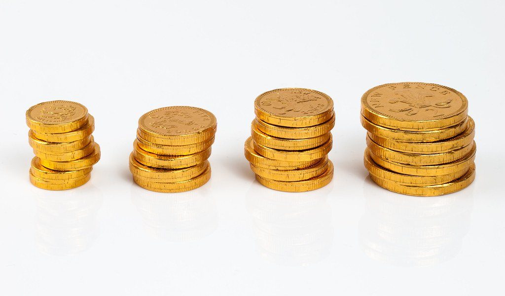Four small stacks of gold-coloured coins of increasing height