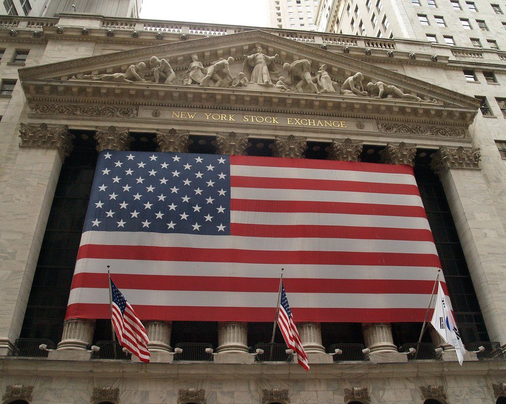 The New York Stock Exchange building draped with a large US flag