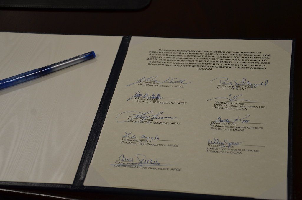 A signed agreement with several signatures and a pen
